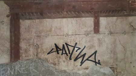 Un turist s-a semnat cu marker cu tus negru pe zidul unei stravechi locuinte romane de langa Pompeii. Risca o amenda uriasa