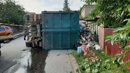 Un camion care transporta gunoi menajer s-a rasturnat langa gardul unei locuinte din Botosani. FOTO