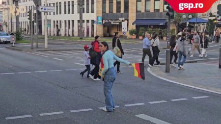 Nemtii sarbatoresc calificarea in optimi. O tanara indeamna soferii sa claxoneze, cu steagul Germaniei