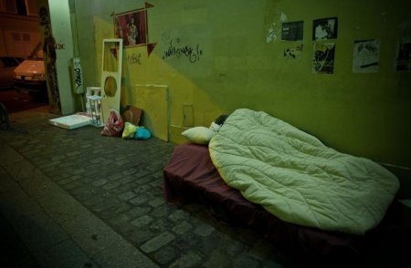 O femeie in<span style='background:#EDF514'>SARCINA</span>ta si iubitul ei traiesc intr-un pat pus pe o strada. Trecatorii trec pe langa ei si se uita bulversati