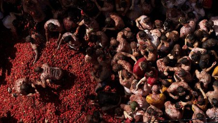 VIDEO Cel mai mare festival la care oamenii platesc sa se bata cu rosii: 22.000 de participanti au colorat strazile din Spania in rosu