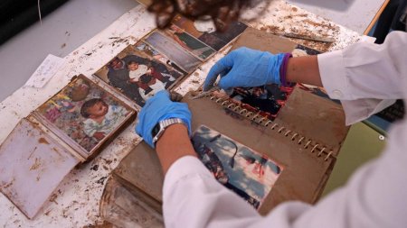 O femeie din Spania a facut eforturi disperate sa-si salveze fotografiile de familie dupa inundatii. Un soldat le-a carat cu o roaba